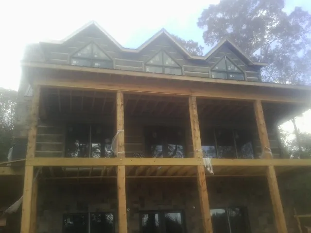 Dormers and porch framing on a large log home under construction — Roof Coating work by our crew in Tuckasegee