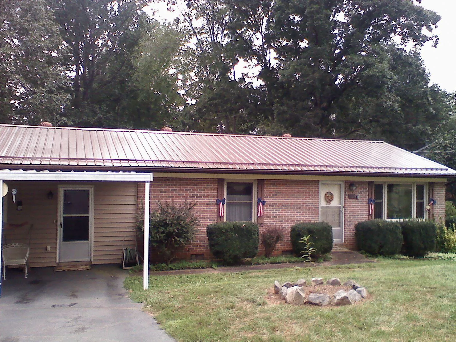 Bronze metal roof and carport on a brick ranch home — Roof Repair work by our crew in Tuckasegee